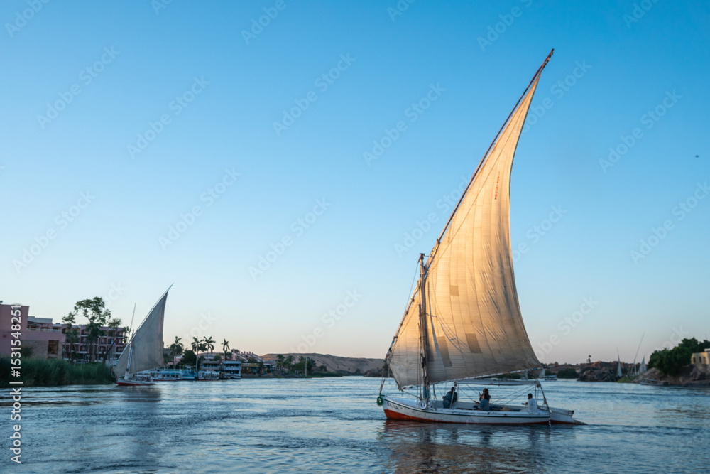 Obraz premium A large sailed sailboat is gracefully floating on the water, Aswan, Egypt
