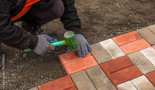 Close-up of a builder installing and laying paving stones on a terrace