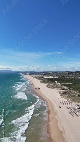 Very high drone view showcasing the Portuguese coastline with green landscapes, cliffs, and vast Atlantic waters. Wide perspective capturing natural textures and coastal geography in southern Europe.
