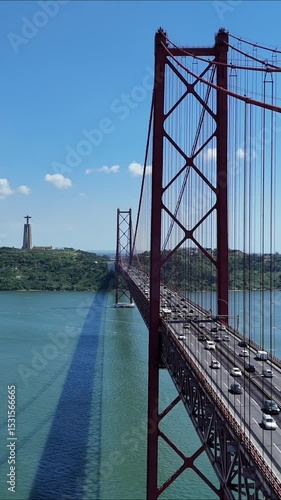 Urban drone flight under the iconic 25 de Abril Bridge in Lisbon, Portugal. Aerial scene capturing the structure’s scale, water reflections, and vibrant city energy from a dynamic, low-angle view.

