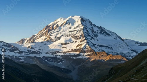 Wallpaper Mural Snowy Mountain Peak Under Clear Blue Sky With Sunlight Warming Snow Covered Slopes Rugged Texture Torontodigital.ca