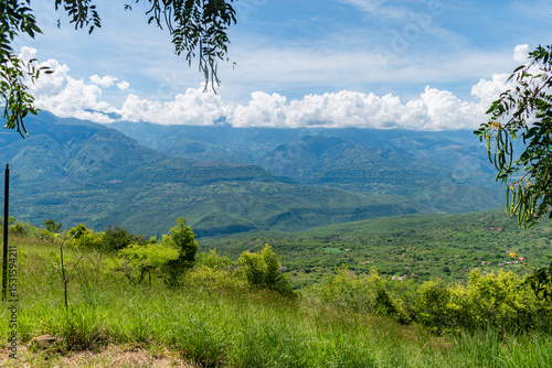 Lush green Colombian mountain landscape on a sunny day, showcasing the vibrant natural beauty and rich vegetation of the region under clear blue skies