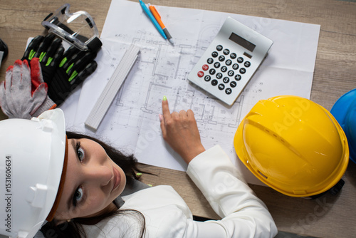 An engineer reviews detailed plans using tools and calculations to ensure precision