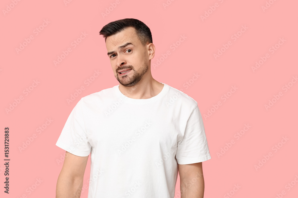 Handsome worried young man on pink background Handsome worried young man on pink background