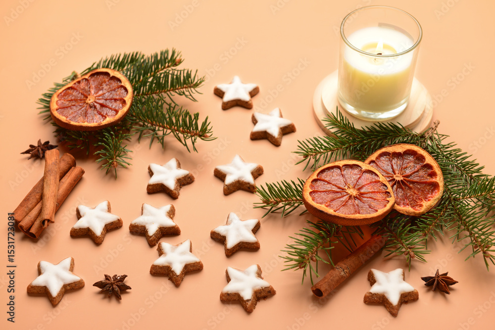 Star-shaped gingerbread cookies with cinnamon, dried orange, fir branches and burning candle on brown background Star-shaped gingerbread cookies with cinnamon, dried orange, fir branches and burning candle on brown background