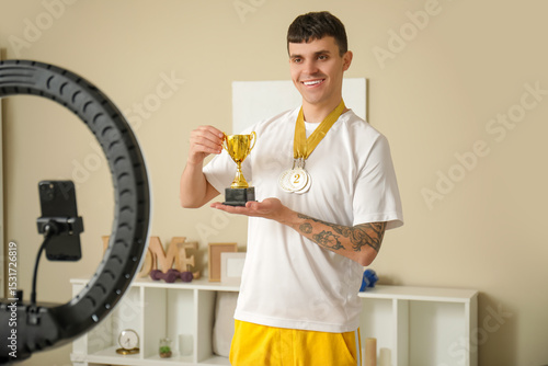 Smiling male vlogger holdin...