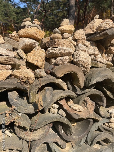 Stacked Stones and Curved Roof Tiles in Nature.
Stone Cairns on Traditional Roof Tiles in Nature.