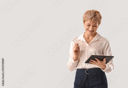Mature businesswoman with tablet computer on white background