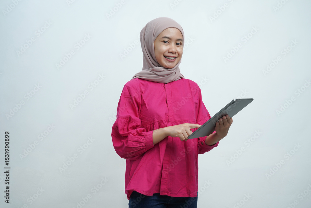 Smiling Muslim Woman in Hijab Using Digital Tablet isolated on White Background Smiling Muslim Woman in Hijab Using Digital Tablet isolated on White Background