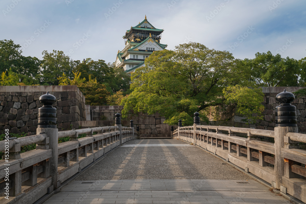 Obraz premium Osaka Castle from the side of the Gokuraku-bashi Bridge over the Inner Moat on a sunny autumn morning, Osaka, Japan