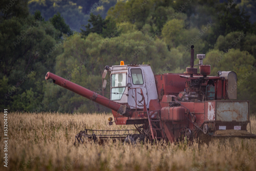 A Soviet combine harvester is working in the field A Soviet combine harvester is working in the field