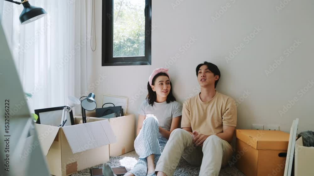 Couple sitting together and taking a break while moving into new home.
Couple sitting together and taking a break while moving into new home.