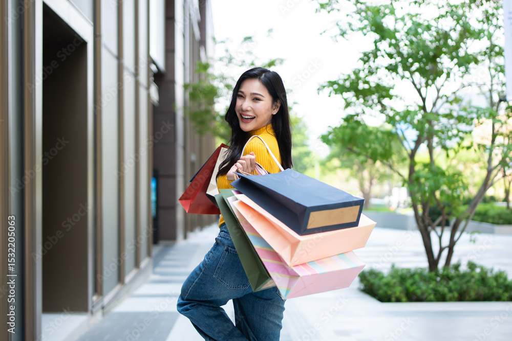 Fototapeta premium Portrait of Asian woman shopping goods outdoors in department store. 