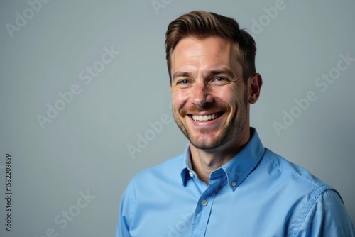 Wallpaper Mural Blue-shirted executive smiling, isolated gray backdrop, management, photography Torontodigital.ca