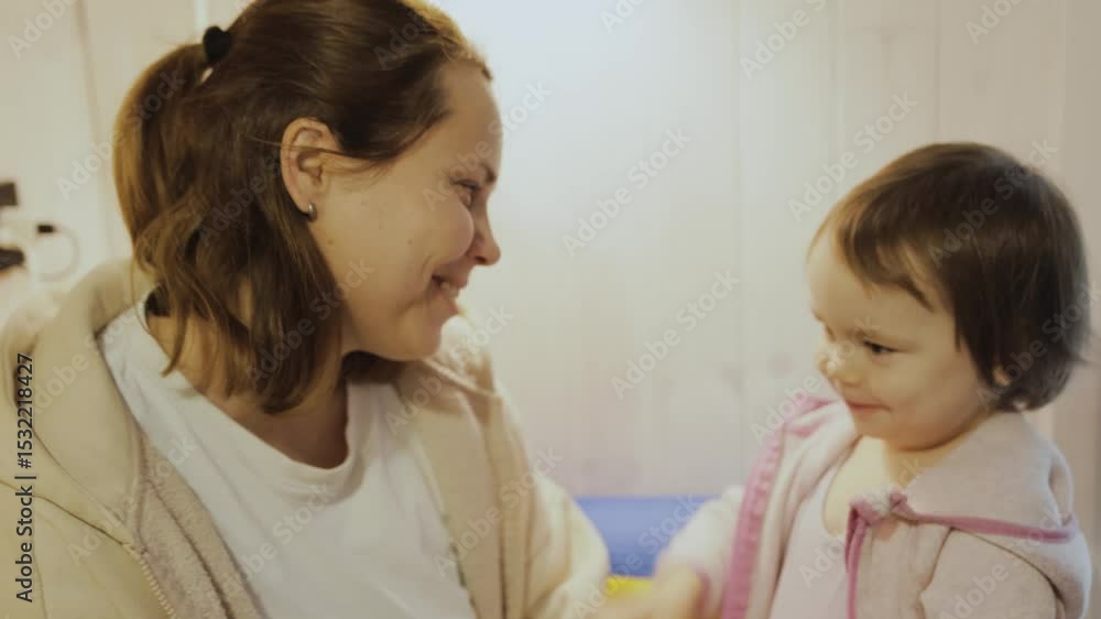 Daughter kisses her mother in a warm cozy room. Tender moments full of love and affection shared between a mother and her child. Mom hugs her child. Daughter kisses her mother in a warm cozy room. Tender moments full of love and affection shared between a mother and her child. Mom hugs her child.