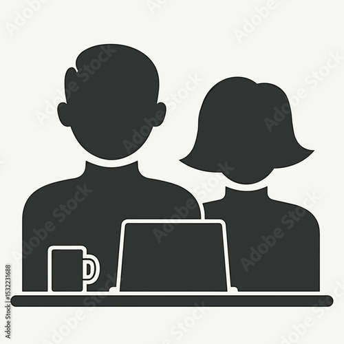 Two people working together at a laptop with coffee cup nearby  