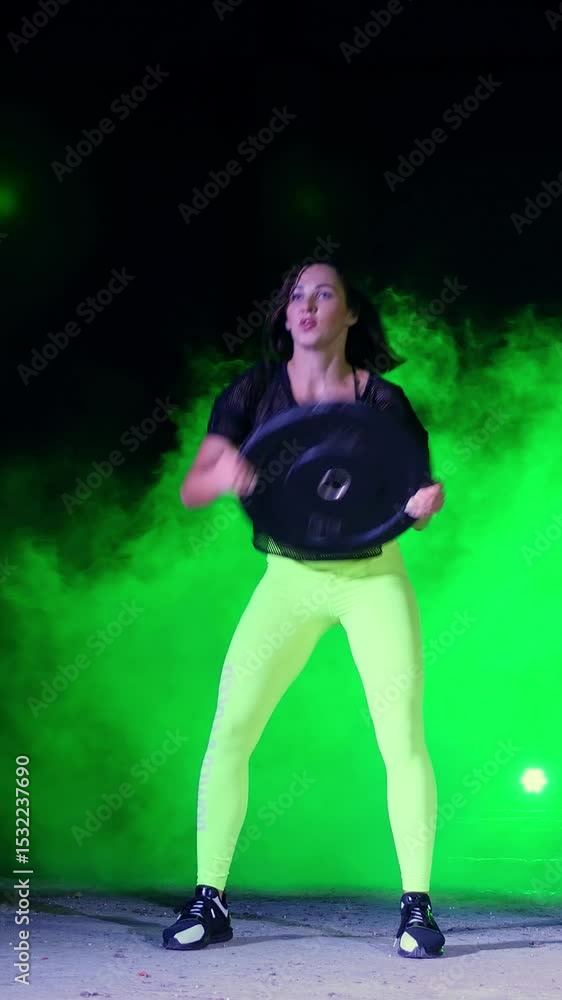 Athletic, beautiful, woman doing strength exercises with heavy weight plates, At night, in light smoke, fog, in light of multicolored searchlights, in an old abandoned hangar, Athletic, beautiful, woman doing strength exercises with heavy weight plates, At night, in light smoke, fog, in light of multicolored searchlights, in an old abandoned hangar,