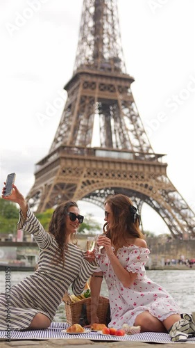 Stylish women take selfie with champagne at Paris picnic spot