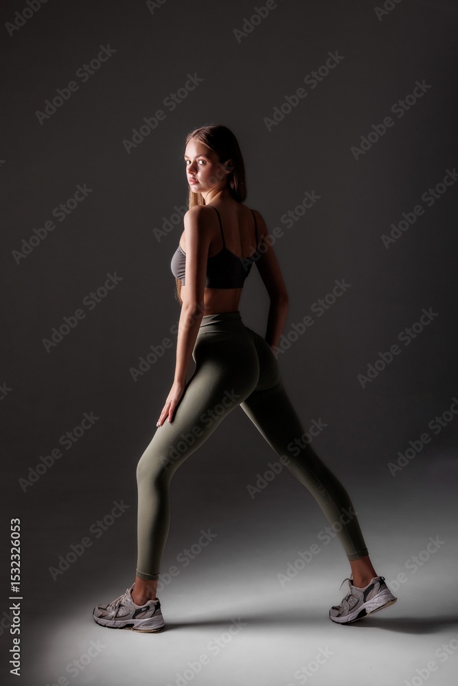 Dynamic fitness pose showcasing strength and style in a minimalist studio setting Dynamic fitness pose showcasing strength and style in a minimalist studio setting