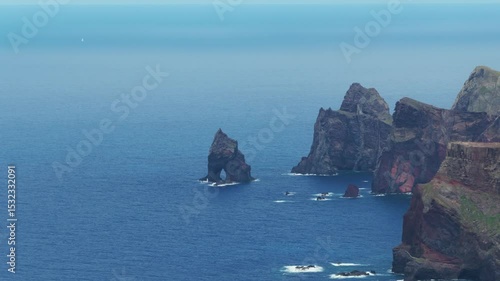 Volcanic sea stacks off rugged coastline of Calhau da Furna do Bode, Madeira, Portugal. Aerial drone lateral view