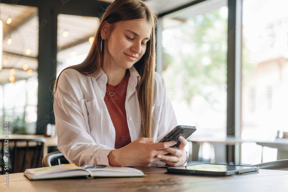 Customer is sitting by the table. Young woman is in the cafe at daytime Customer is sitting by the table. Young woman is in the cafe at daytime