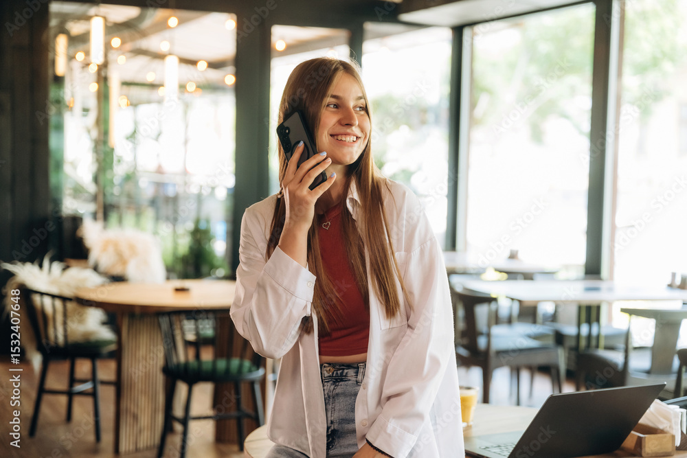Conversation by phone, talking. Young woman is in the cafe at daytime Conversation by phone, talking. Young woman is in the cafe at daytime