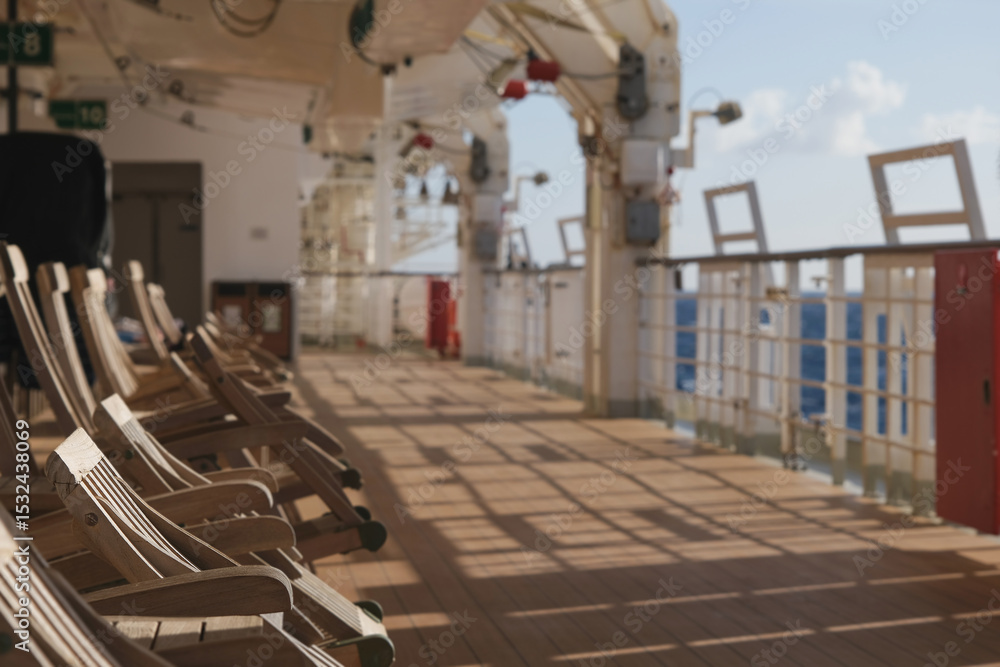 Obraz premium Outdoor promenade boat sun deck onboard modern luxury cruiseship cruise ship ocean liner with teak wood loungers and deck chairs for guests passengers with ocean views