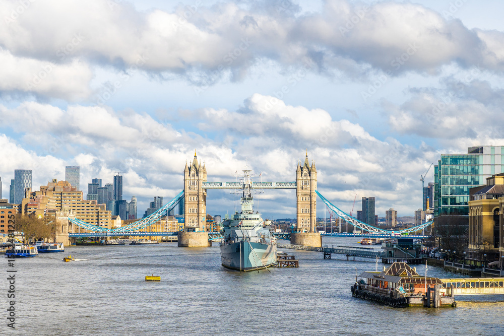 Obraz premium Hms belfast warship sailing under tower bridge in london, united kingdom