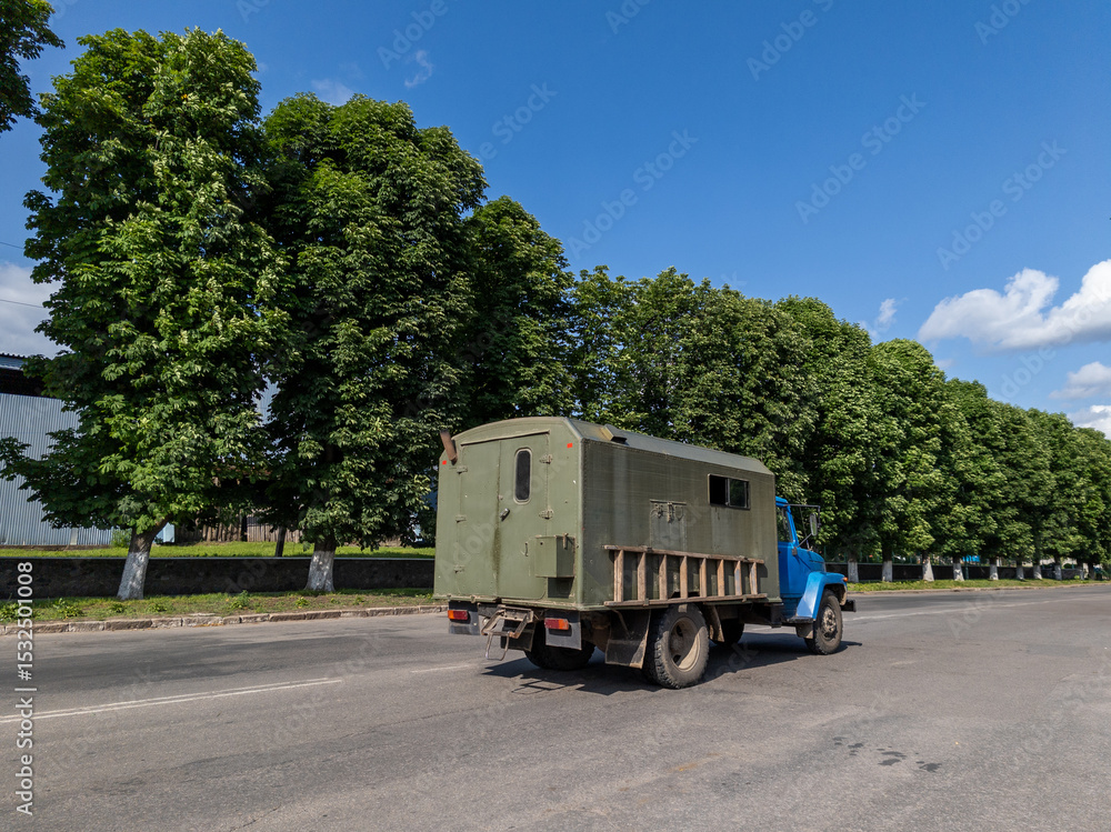 Obraz premium A military truck travels along the asphalt road