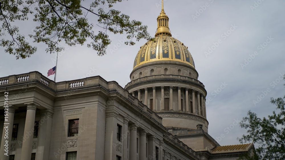 Fototapeta premium Visitors admire the stunning golden dome of the West Virginia State Capitol, surrounded by beautiful architecture, capturing a significant piece of Charlestons history.