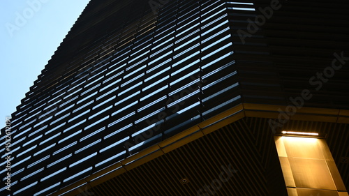 Tablou pe pânză Modern architectural facade with horizontal louver pattern and dramatic lighting