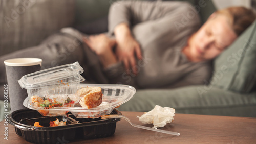 Woman with bloating and stomach pain after fast food meal