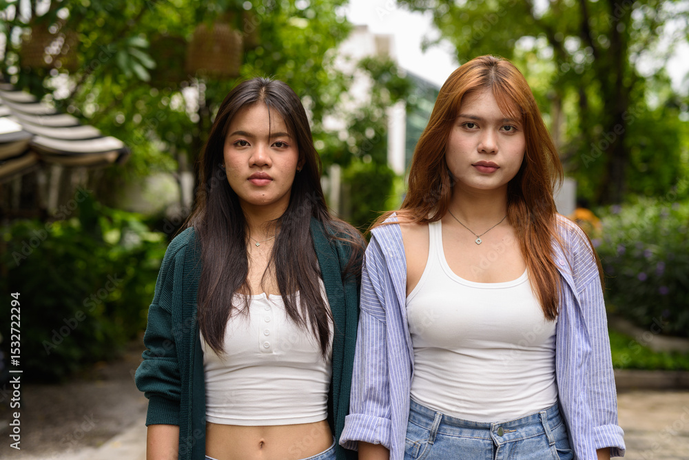 Obraz premium two teenage girls in park looking at camera