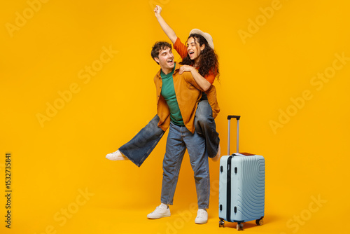 Konstfotografi Excited European couple with luggage having fun over orange studio background, w