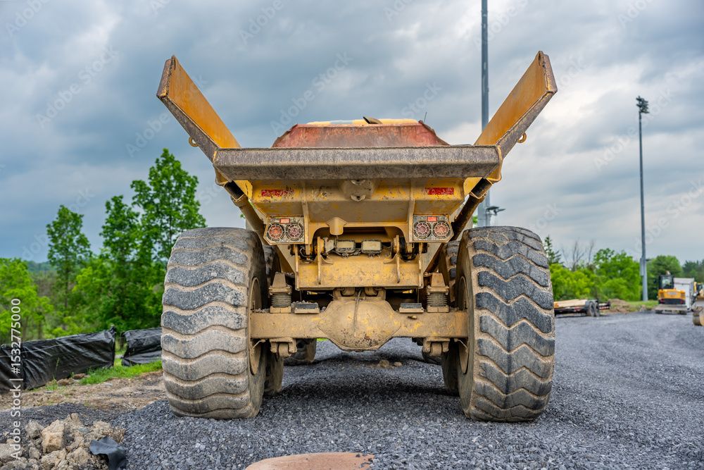 Obraz premium Back of an empty large industrial dump truck on a construction site. 