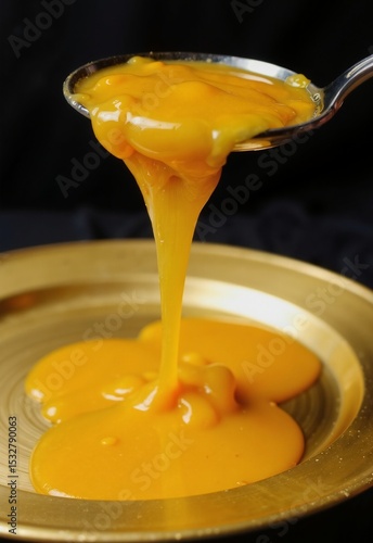 Wallpaper Mural Golden syrup being poured from a spoon onto a plate, creating a smooth, glossy layer of caramelized liquid Torontodigital.ca