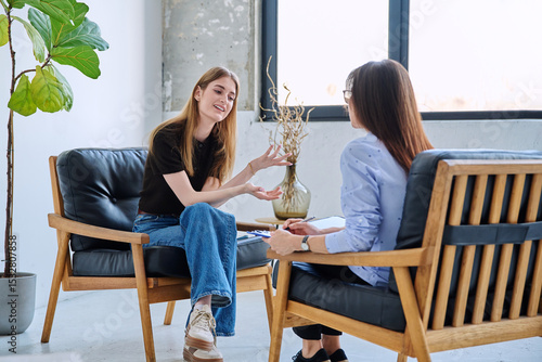 Young smiling girl patient in therapy session with social mental therapist