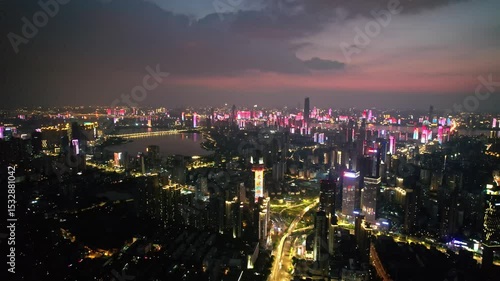 Evening illumination over wuhan riverfront cityscape with colorful building lights, china, illuminating the dusk skyline