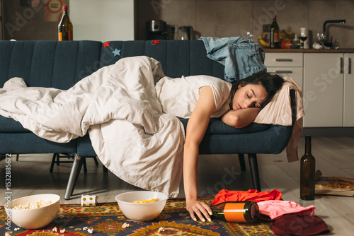 Obraz na plátně Young woman sleeping on sofa after house party