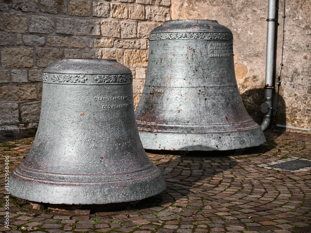 Fototapeta premium Two old church bells stand on a square