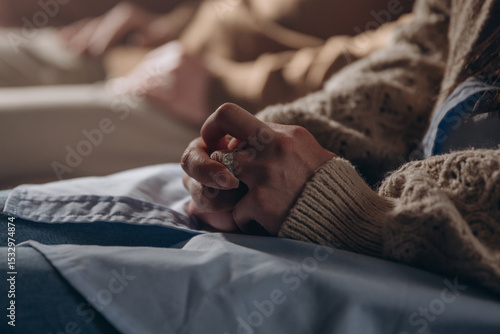 Photos Upset woman twists ring on finger sitting on couch in therapy office