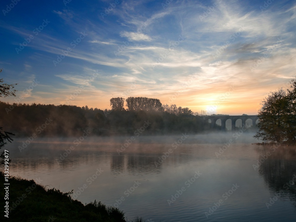 Fototapeta premium Lake with a bridge in the background at sunrise