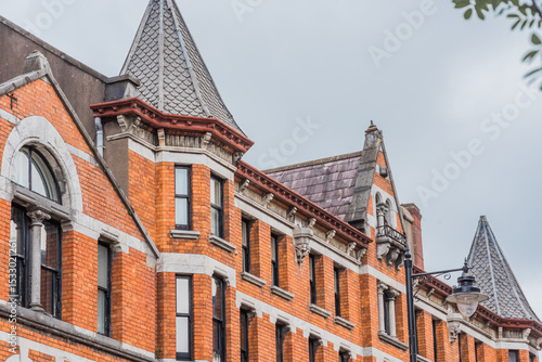 Victorian Gothic exterior, distinguished by its bold orange color and elaborate architectural ornaments.