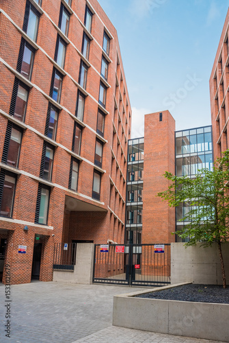 Residential steel structure featuring concrete, brickwork, and large windows.