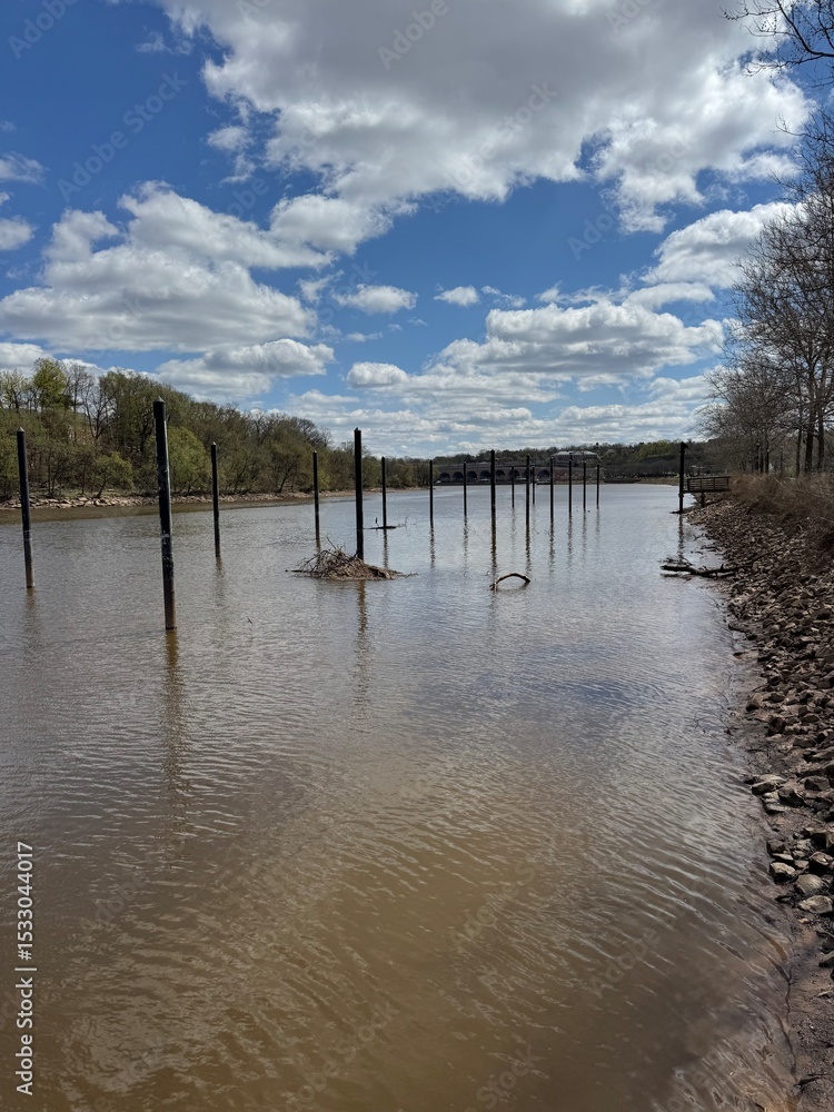 Fototapeta premium River poles stretching into the distance under partly cloudy skies – New Brunswick, NJ