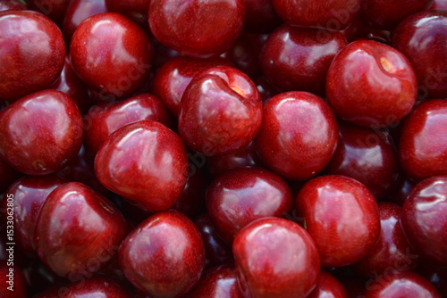 Extreme close-up of shiny ripe cherries with smooth skins and deep red tones, ideal for fruit texture backgrounds, organic produce, or juicy summer food visuals