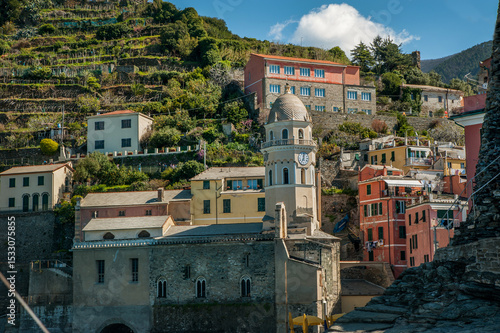 The colorful houses of Vernazza, with its charming church tower and green ter...