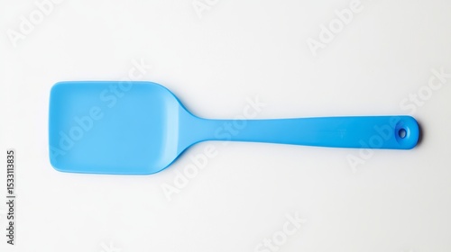 Against a white background, a spatula made of bright blue plastic is visible