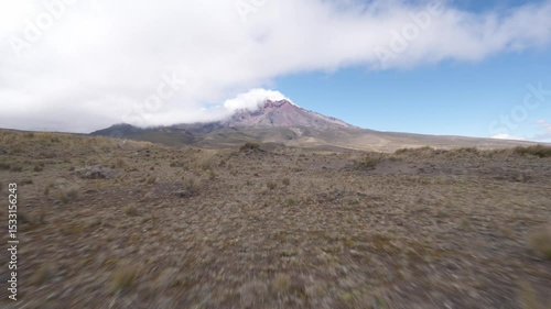 Aerial journey revealing rugged Andean paramo landscape surrounding snow capped Chimborazo volcano, capturing expansive wilderness and geological majesty of Ecuadorian highlands