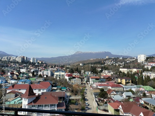 Wallpaper Mural Scenic aerial view of a vibrant residential area with colorful rooftops, surrounded by mountains and clear blue sky, showcasing urban landscape and natural beauty Torontodigital.ca